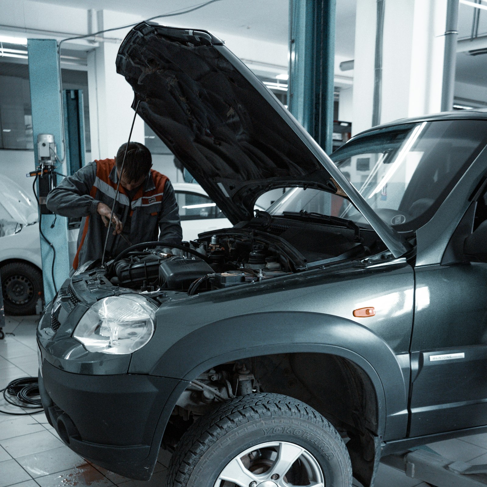 Technician working beneath a raised vehicle